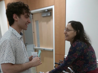 Noah Daube-Valois speaks to Jean Smith, a resident of a nursing home in Northampton.